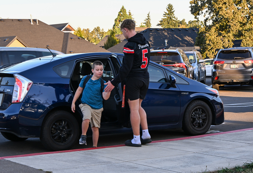 Football players greeting students