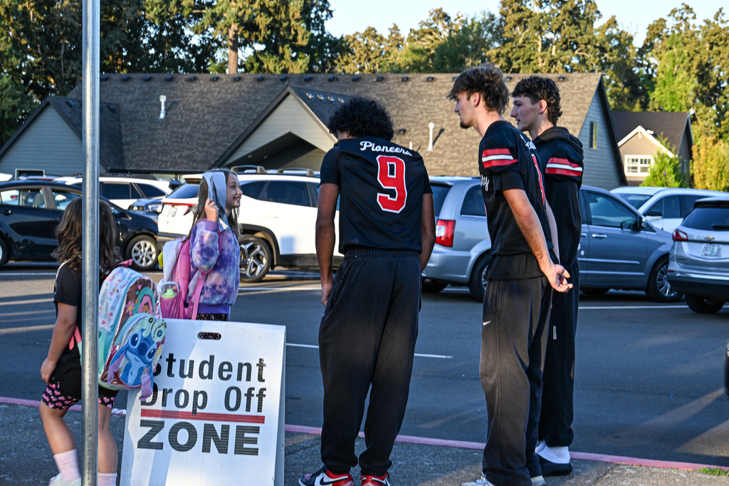 Football players greeting students