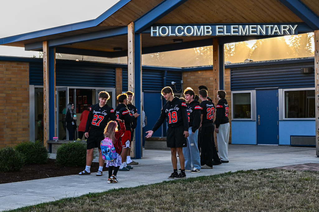 Football players greeting students