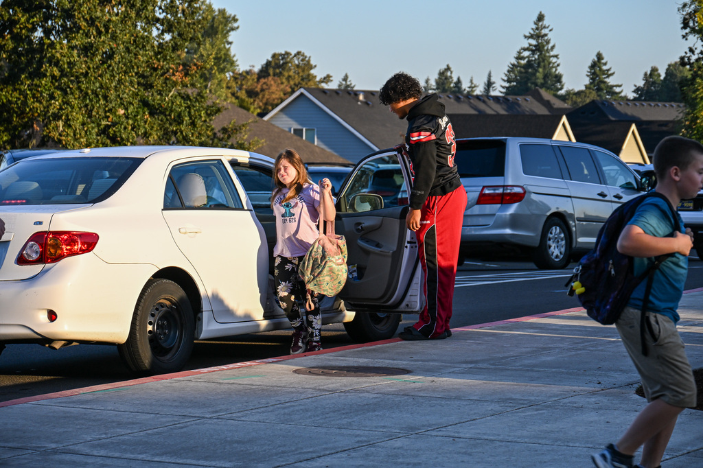 Football players greeting students