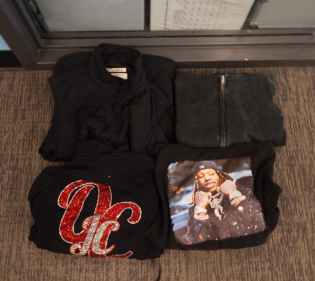 Four jackets/shirts - 1 OC Cheer, 2 black sweatshirts, 1 black t-shirt with a rapper on the front