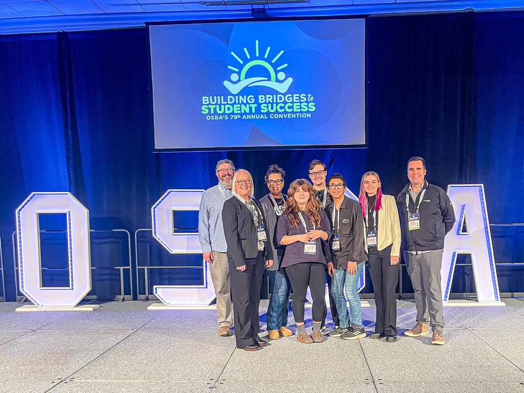 SSAC students, Dr. Spitzer and three board members posing in front of OSBA sign.