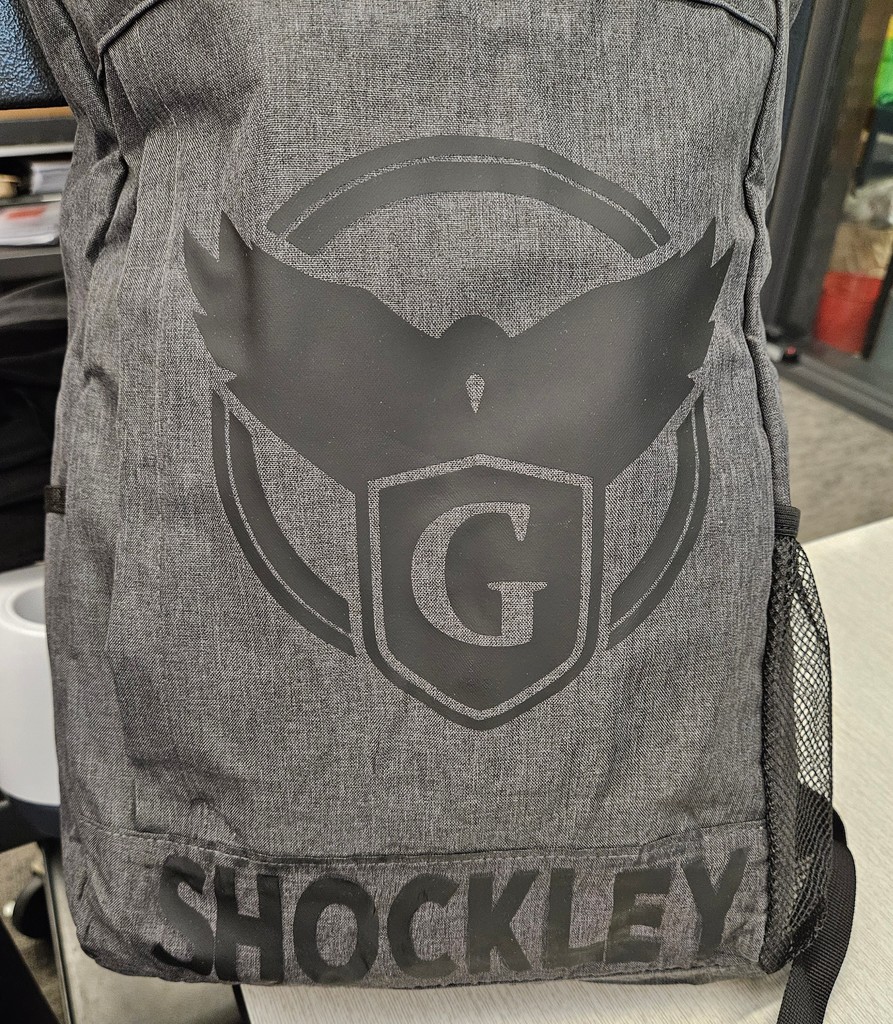 Grey backpack with black Gardiner logo and Shockley name.