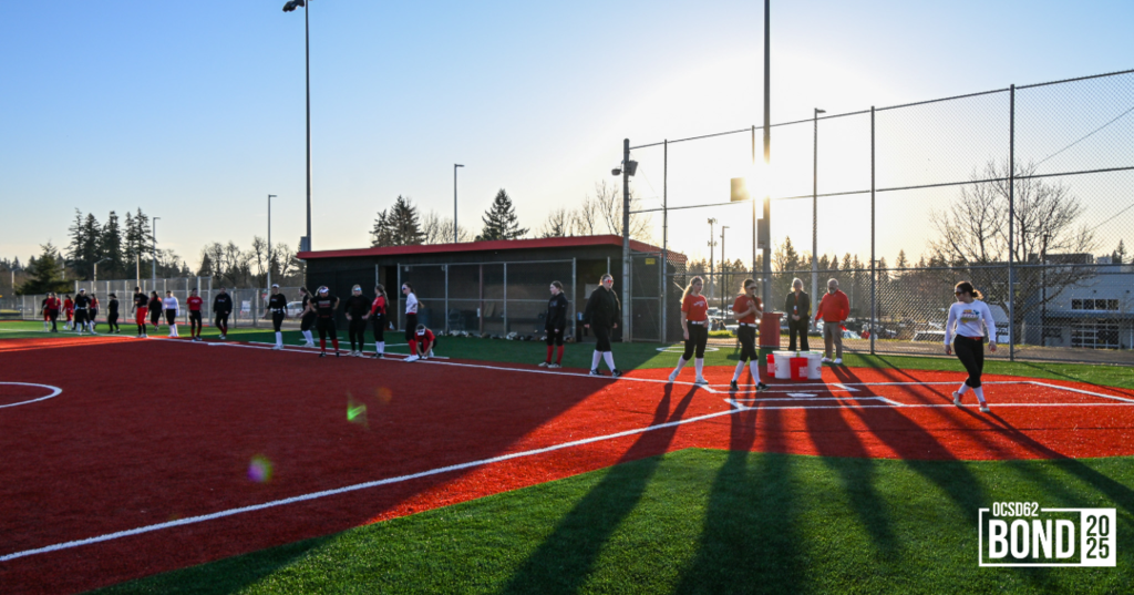 Softball players on new turf surface getting ready to practice.