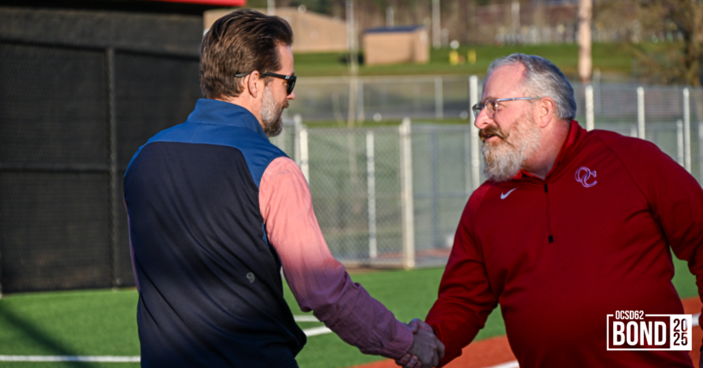 OCHS Principal Greg Timmons shaking hands with OTAK bond team member Dennis Petross. 