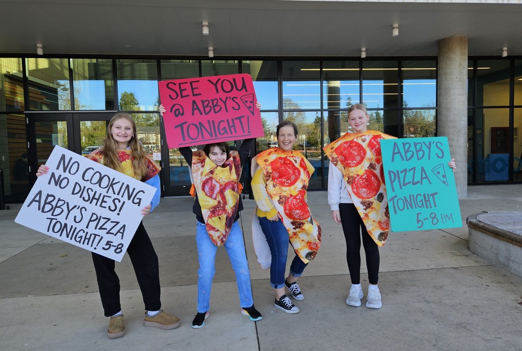 4 people dressed in pizza costumes, holding signs encouraging people to eat at Abby's tonight from 5 - 8 p.m.