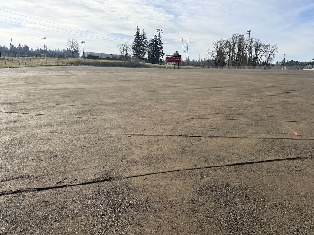 OCHS Varsity Baseball field being prepped for turf surface installation, gravel has been pressed flat and the new scoreboard shows at the edge of the field.