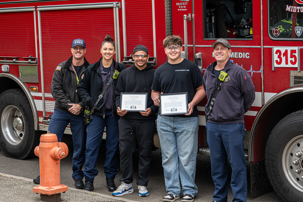 Elyjah and Blake posing with fire fighters in front of a fire truck