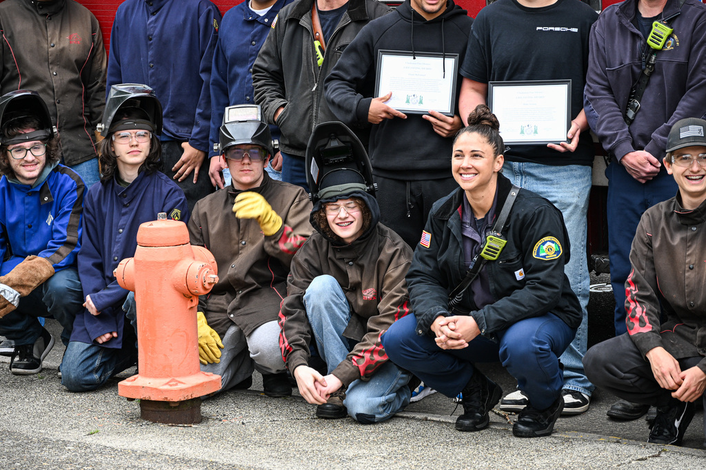Students posing with fire fighters for pictures