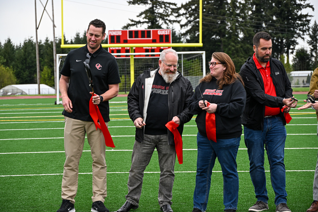 Board members, OCHS athletic director and OCHS principal holding cut ribbon