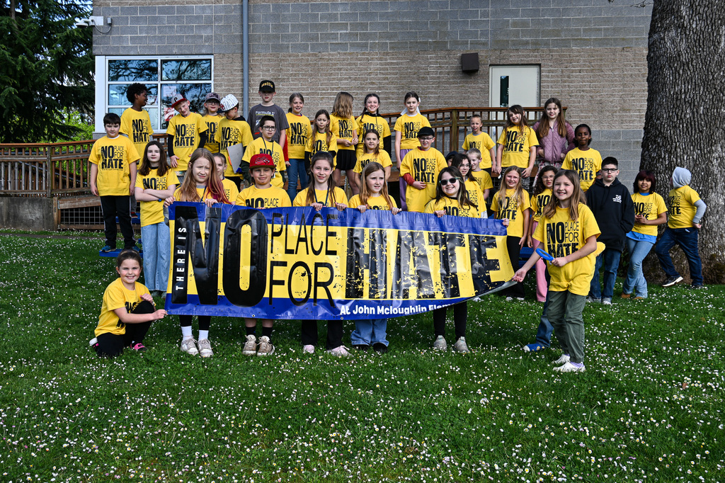 JME Students wearin yellow shirts and holding a banner that says "No Place for Hate"