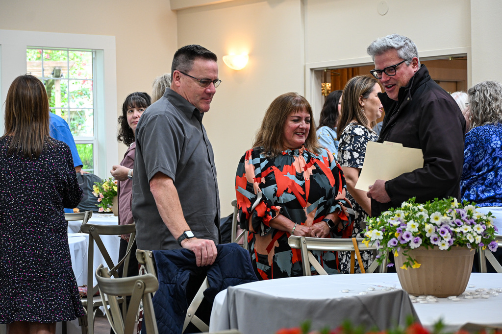 Diverse group of people standing around chatting before an event