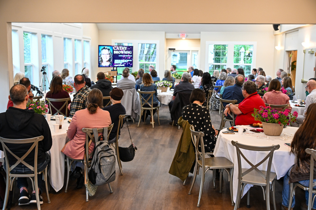 A diverse group of people sitting at tables at an event