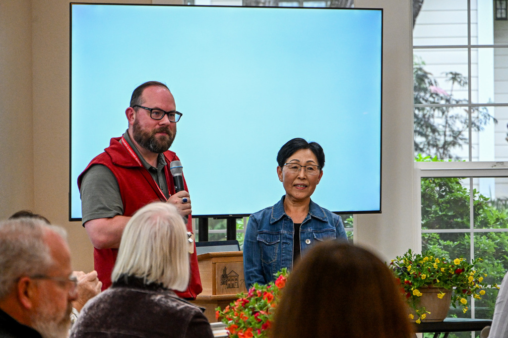 Man holding a microphone standing next to a woman smiling