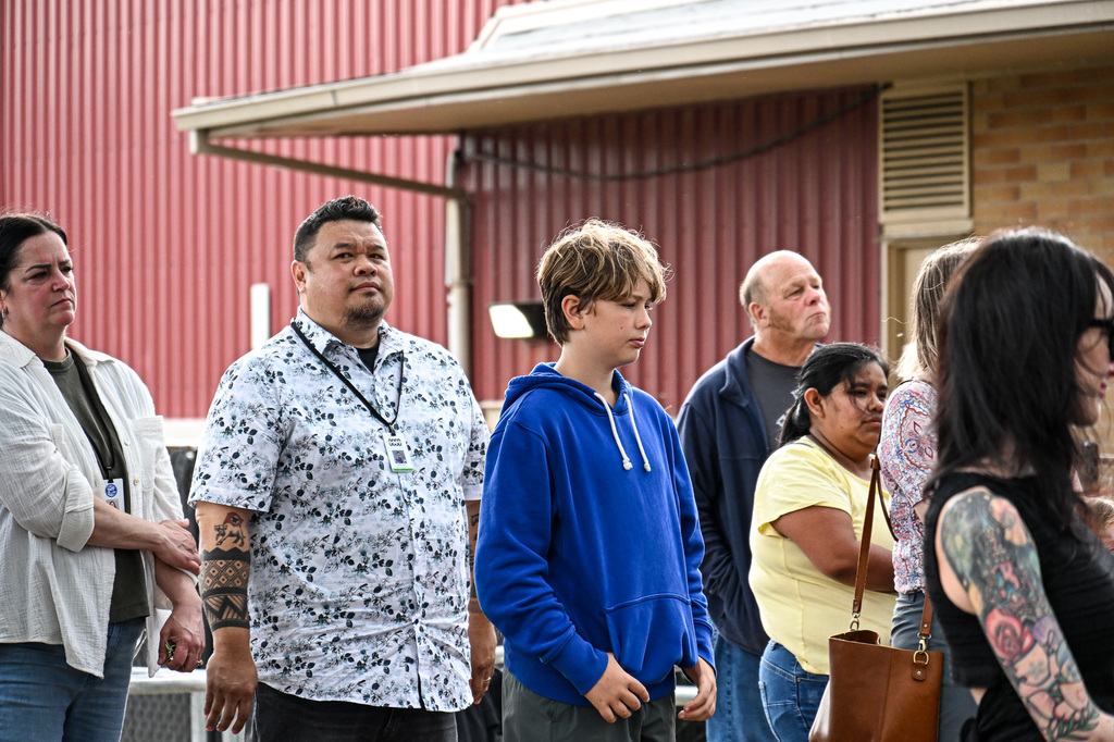 Candy Lane families and a district staff member listen attentively to a speaker during the groundbreaking ceremony.