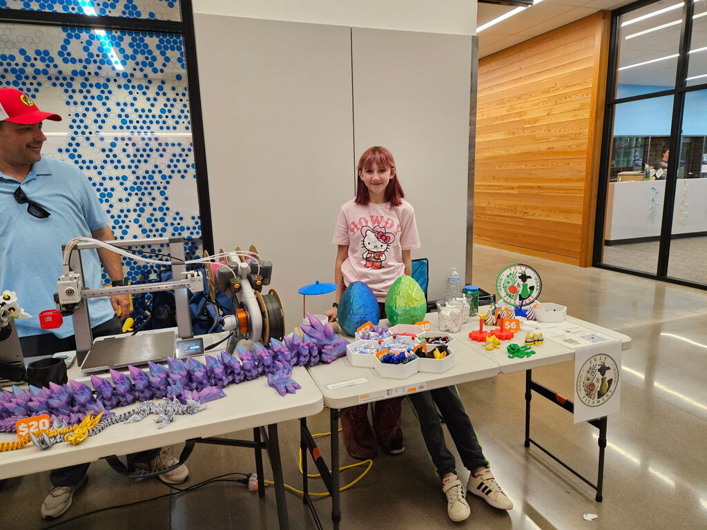 Student standing behind table with 3D merch