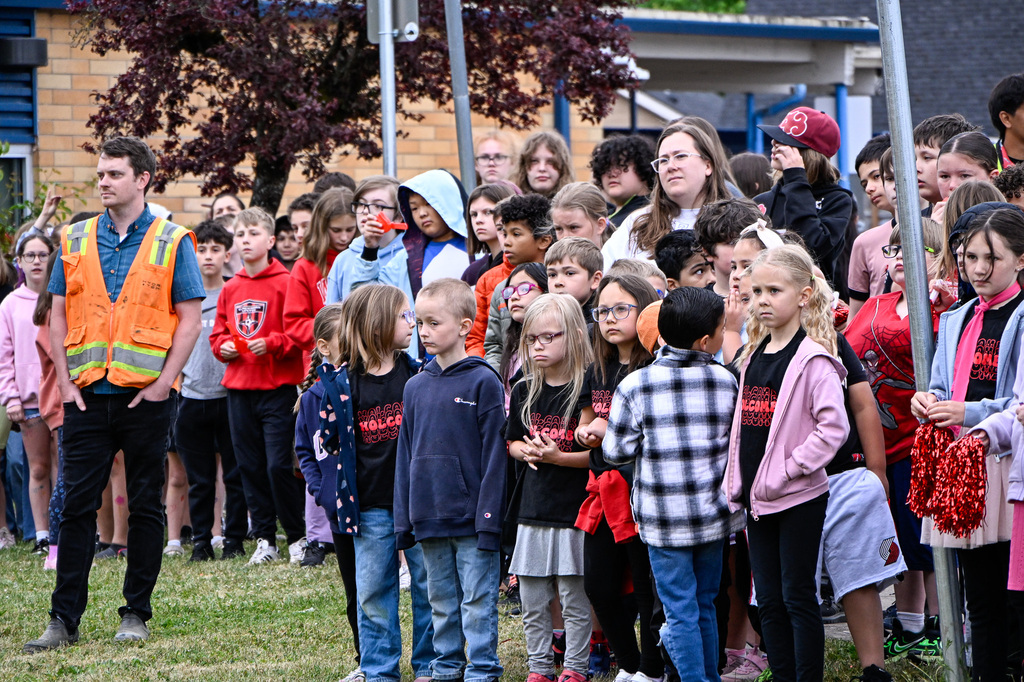 Holcomb students and staff watch and listen to a speaker in a group