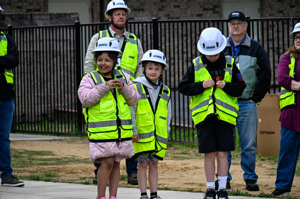 Students wearing hard hat and vests smiling