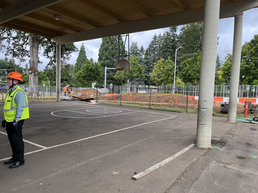 Person wearing a hard hat standing infront of construction zone.