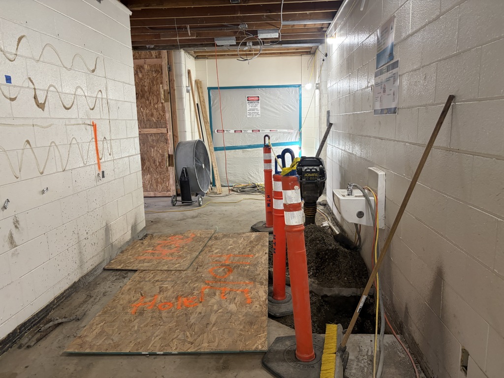 Hallway under construction with three orange cones.