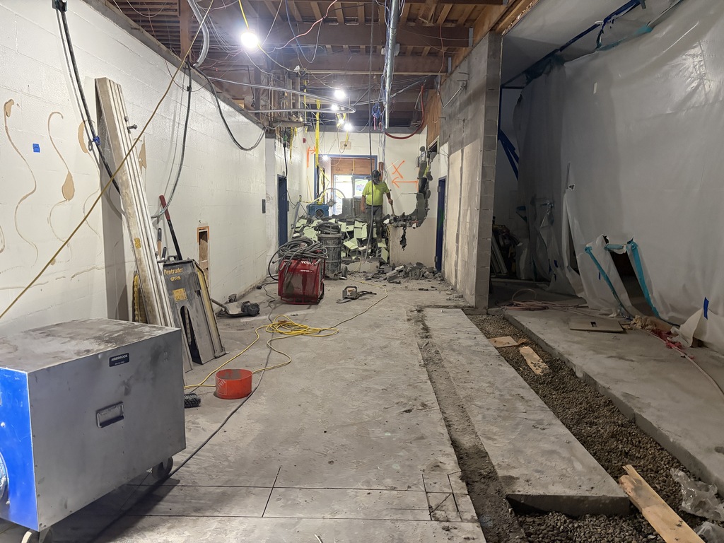 Hallway with construction person working at the end of the hallway.