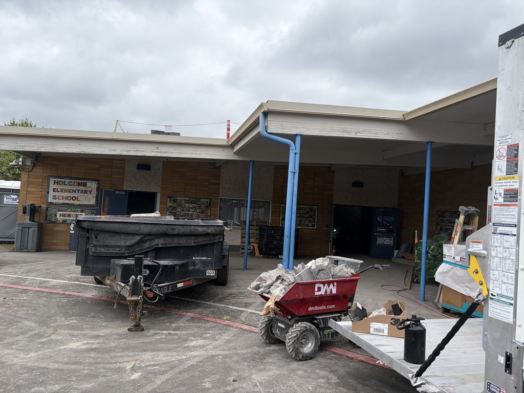Front of school with construction trailer and materials.