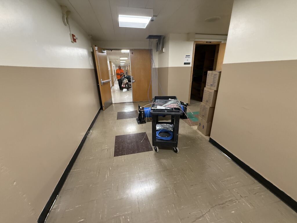 Hallway with construction worker and wiring cart.