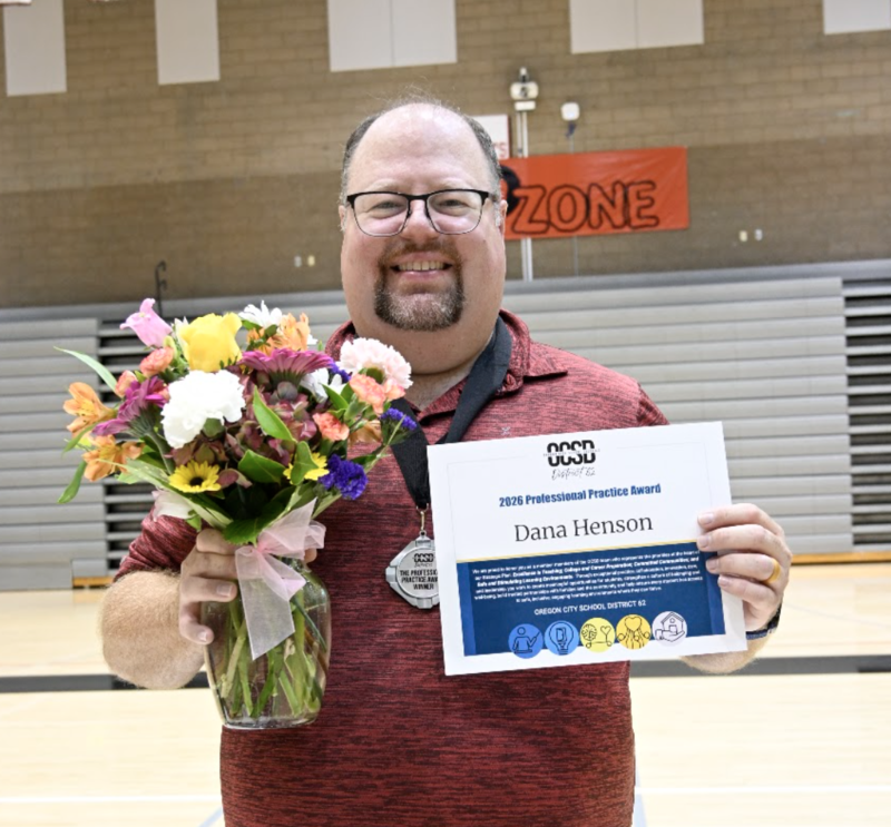 Dana standing with flowers and award certificate