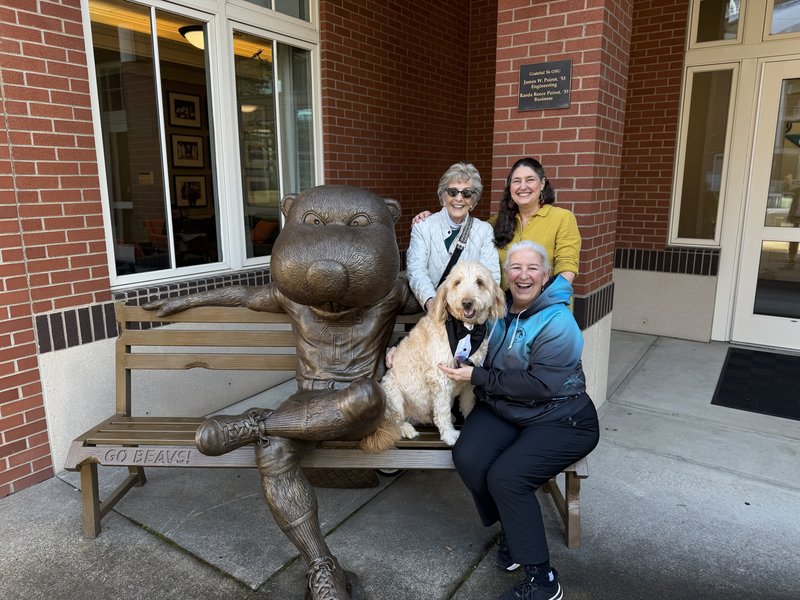 Benny next to statue surrounded by friends