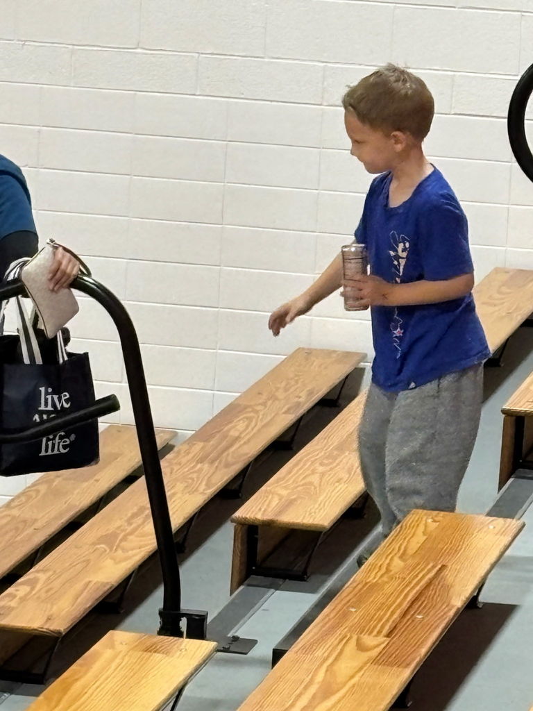 kid picking up trash in bleachers