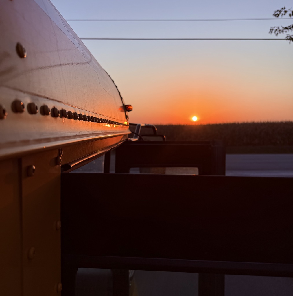 Rising sun over corn & bus door.