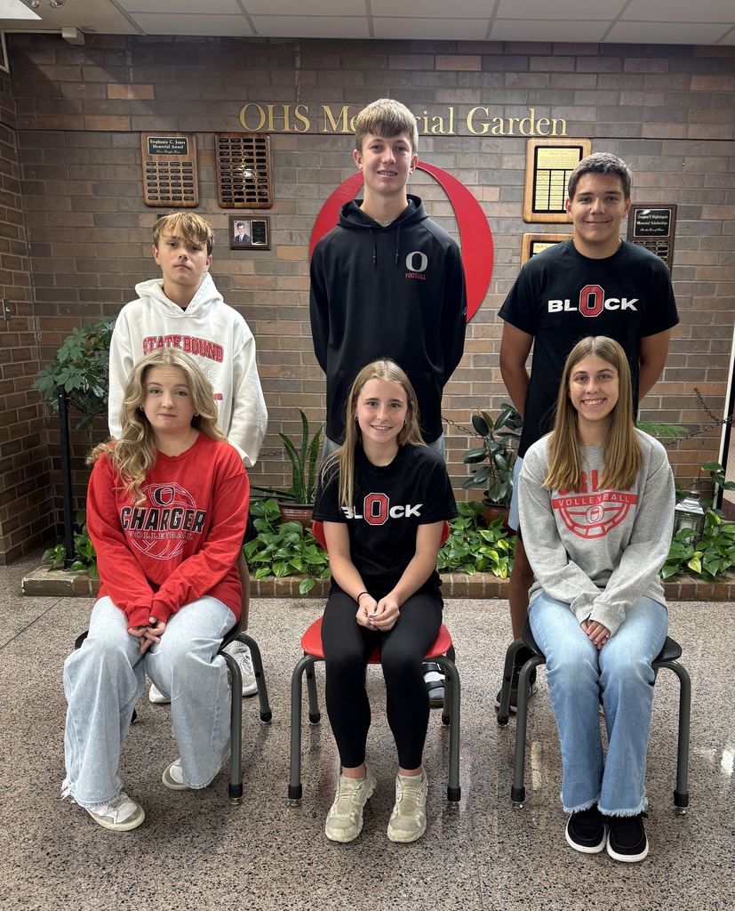 three girls sitting on chairs in front of three boys
