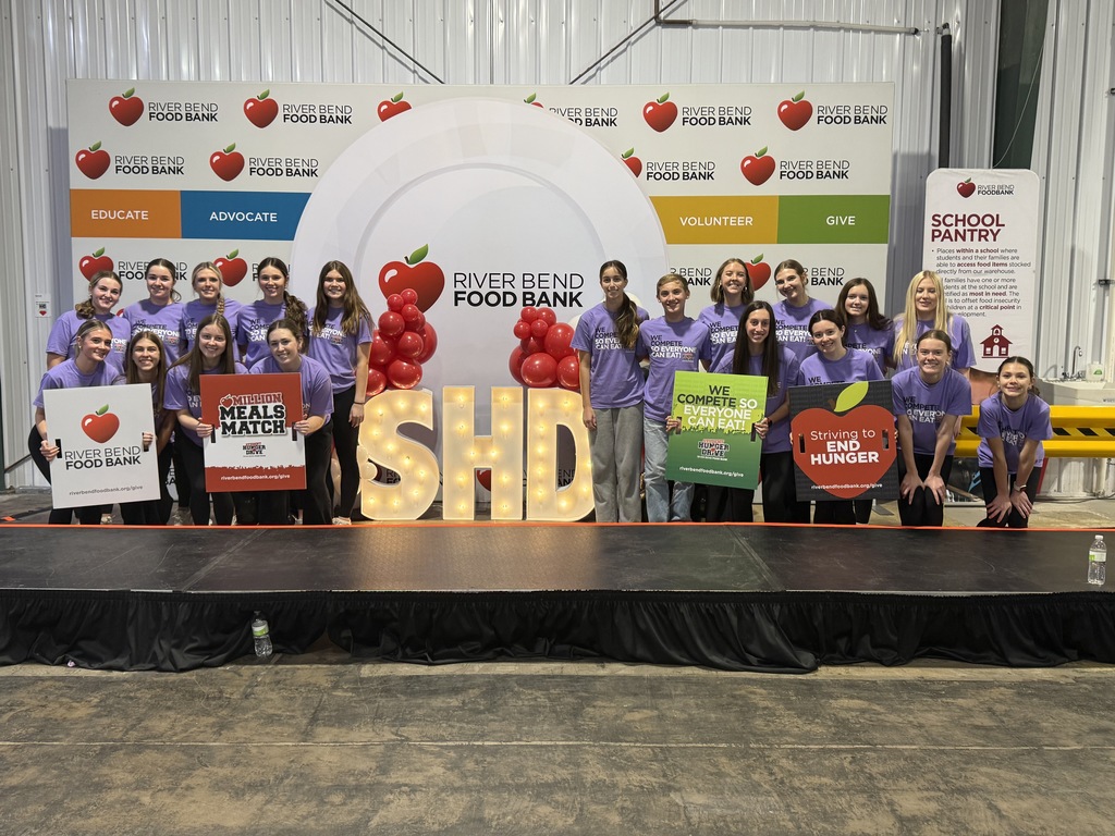 group poses with the sign