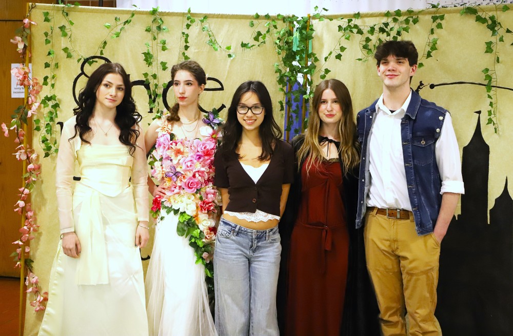 Designer posing with four models at fashion show