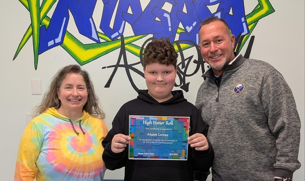 Student stands between two administrators with certificate in his hands