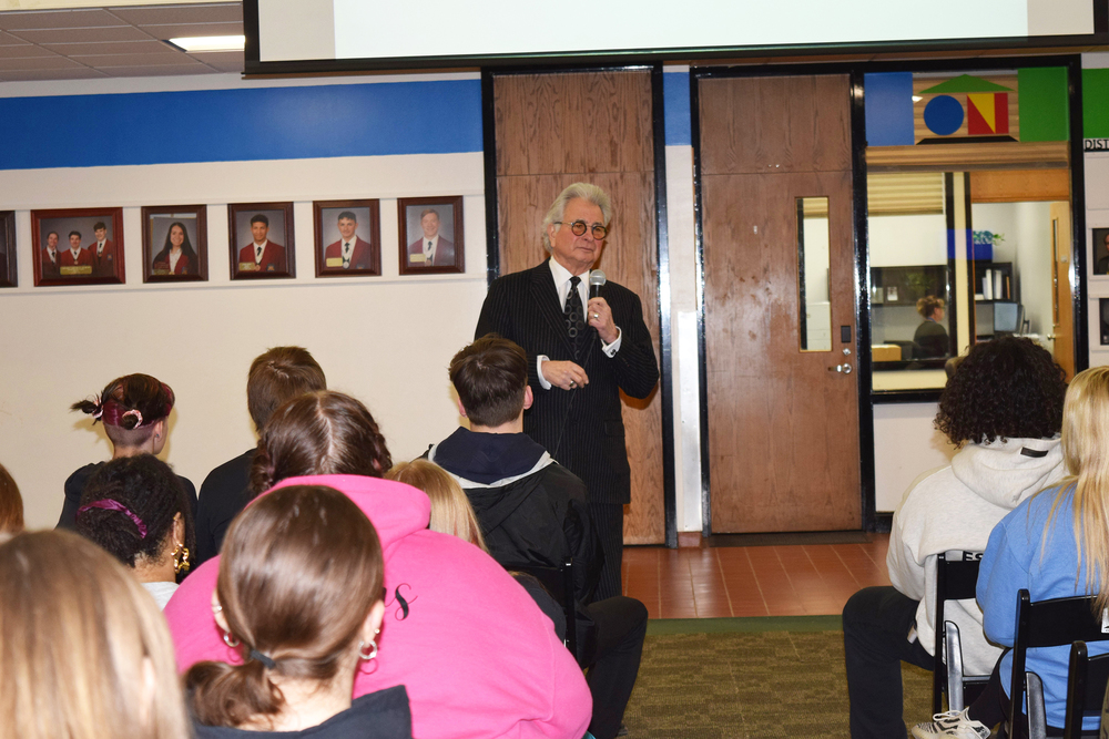 Man on microphone talking to students