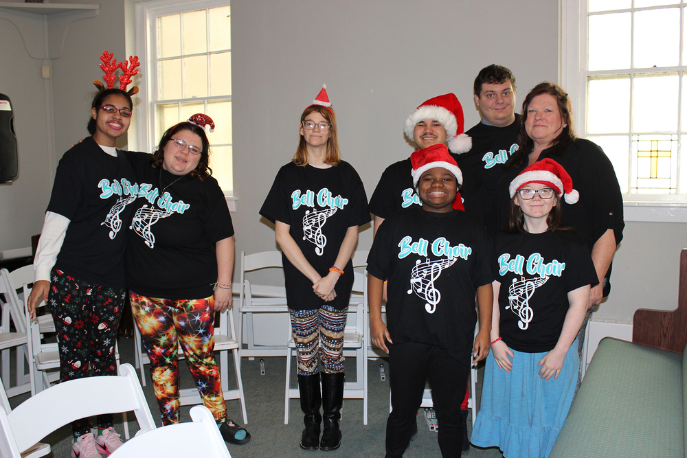 Seven students in holiday garb pose with music teacher