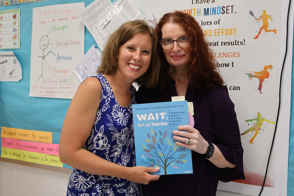 Two teachers holding a book