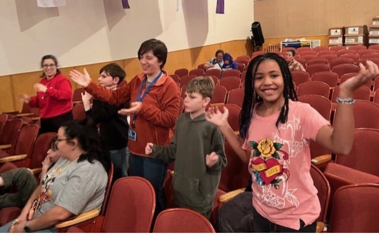 Students and staff dancing in auditorium