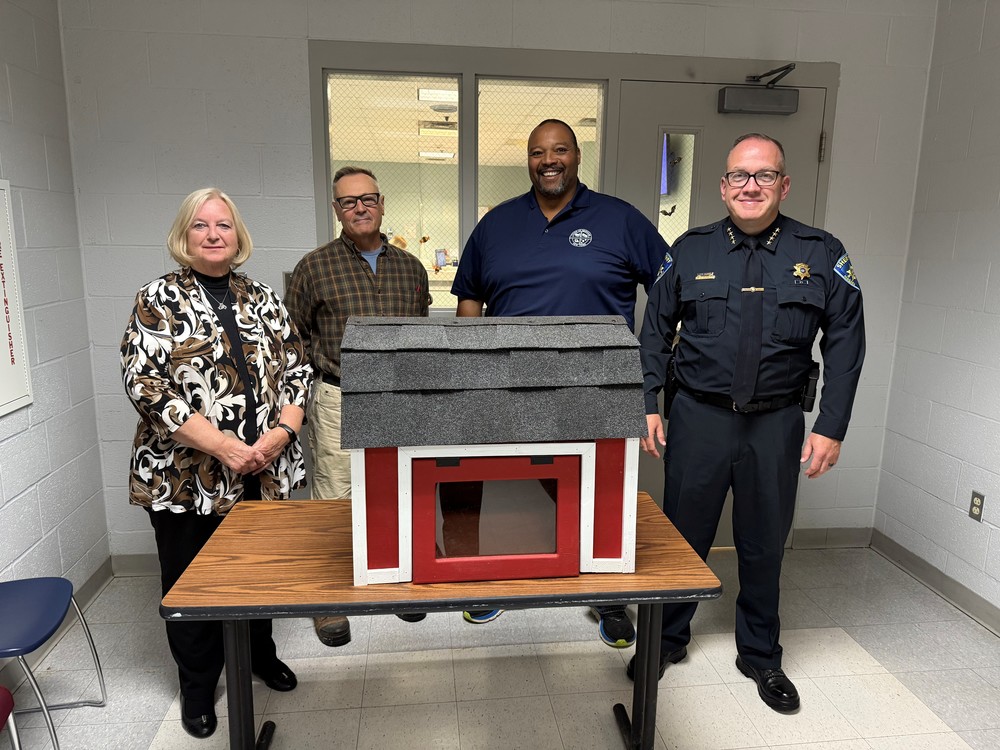Woman and man standing with court officer and sheriff with food pantry