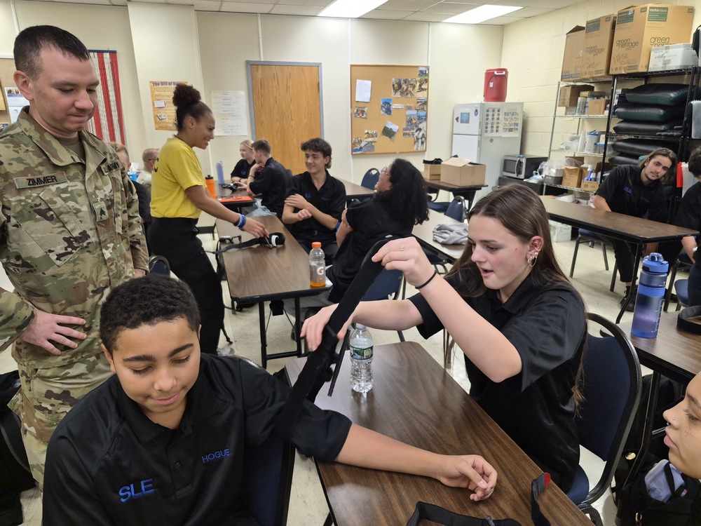 Army National Guard recruiters watches students learn to tourniquet