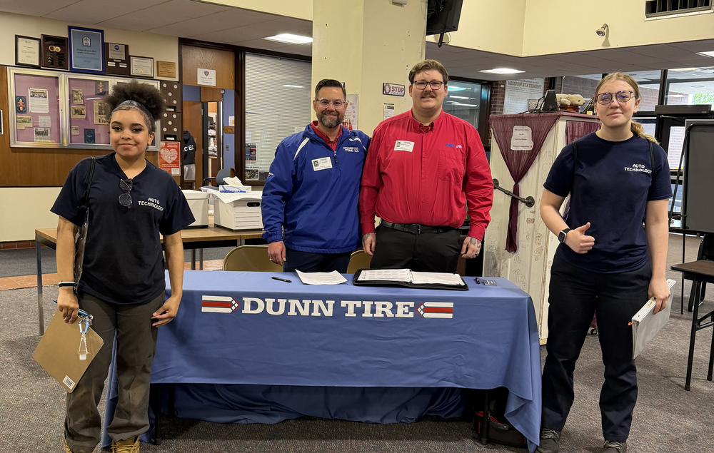 Two students stand with Dunn Tire Reps