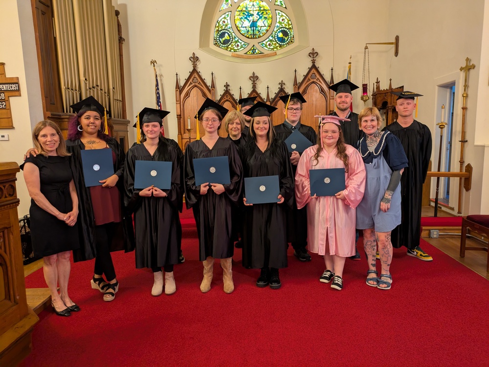 Teachers pose with graduates in church