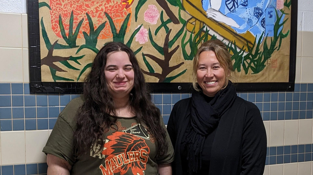 Student standing with district superintendent