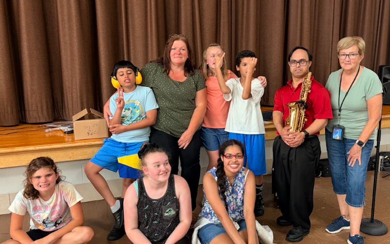 Teachers and musician posing with students