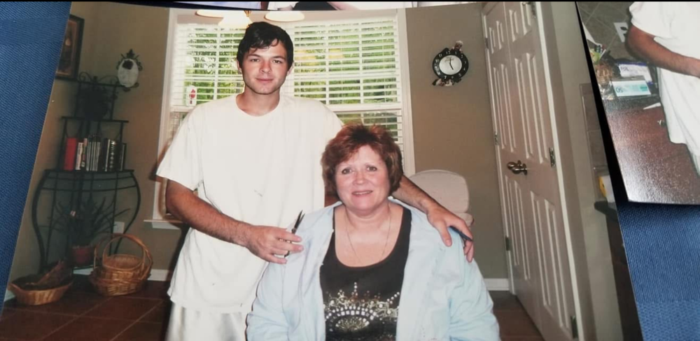 Student holding scissors and posing with client in shop