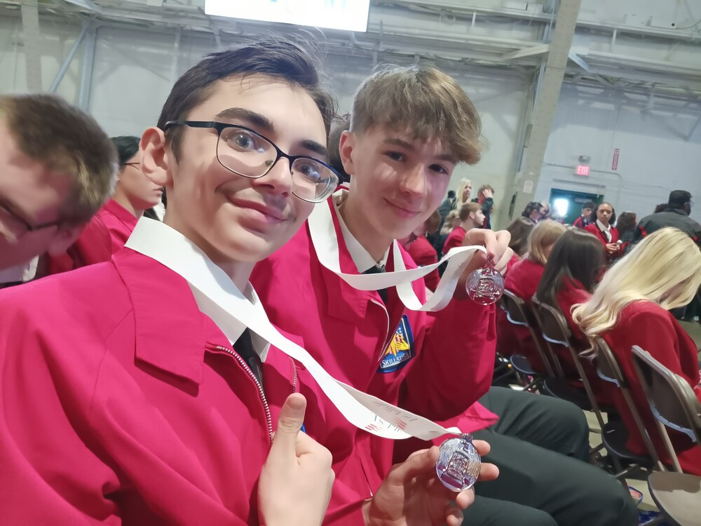 Two students showing off silver medals