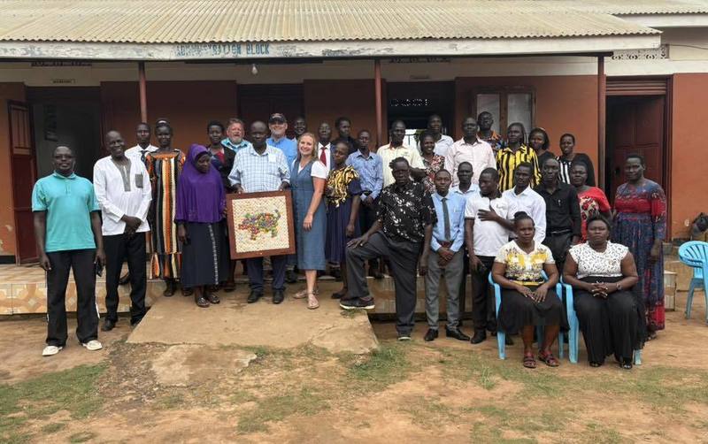 People posing in front of school