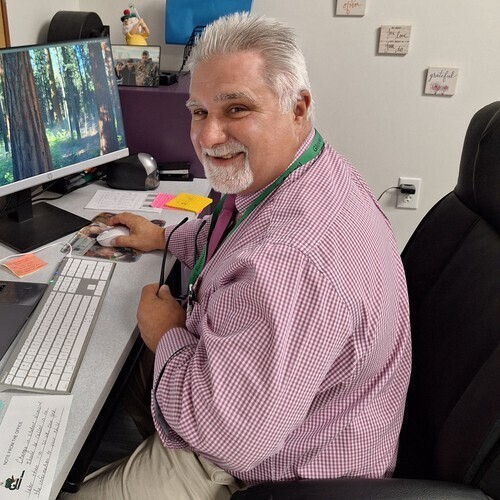 Principal Fiorientino sitting at his desk, smiling