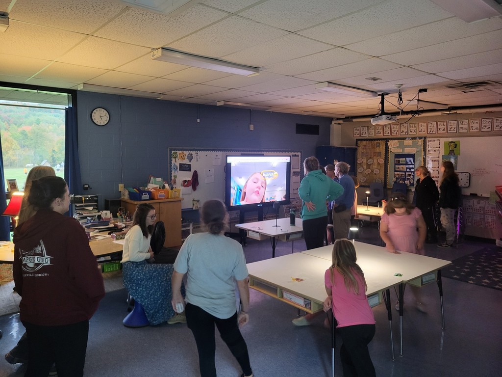 families watching video in the classroom during open house 
